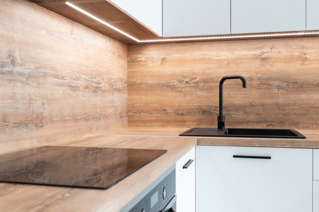 Modern kitchen with wooden wall and white cupboard