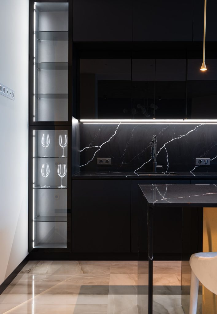 Kitchen interior with black cabinets in soft illumination