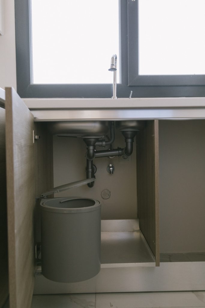 Gray Garbage Can Under Kitchen Sink